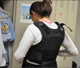 Photo 2 - Female officer puts on bulletproof vest